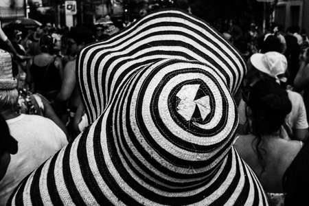 Hat with black stripes and the crowd in a street carnival party in the background.の写真素材