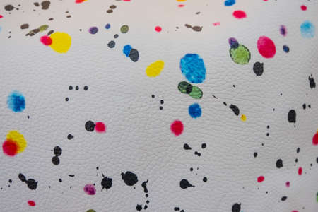 Wallpaper background detail of white leather with colorful splash dots. Fashion fabric texture for...