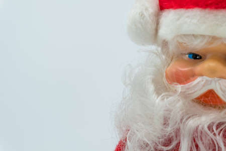 Santa Claus toy figure with silver bell on his hand isolated on white background.の写真素材