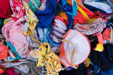 Wallpaper background of colorful women bikini swimsuits in a street retail store basket display. Beach summer clothes. No people.の写真素材