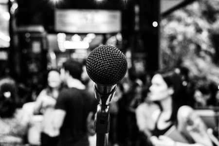 Black and white wallpaper background of a microphone in the street in front of a bar full of people...