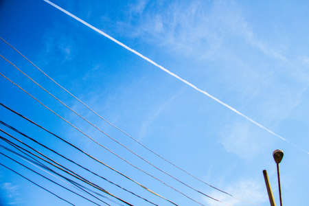 Wallpaper background of an airplane white vapor trace in the blue sky on a summer afternoon. No...