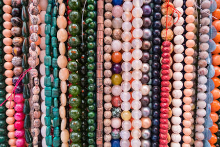 Wallpaper background of colorful necklace made of gemstones and colored beads showcased in a shop. Semi precious jewelery.の写真素材