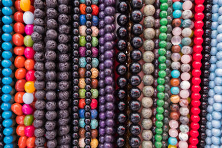Wallpaper background of colorful necklace made of gemstones and colored beads showcased in a shop. Semi precious jewelery.の写真素材