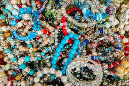 Wallpaper background of stylish bracelets made with colorful stones. Fake jewelery.