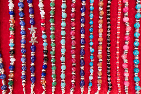 Wallpaper background of a flea market stall with fake vintage jewelery bracelets and necklaces for sale.の写真素材