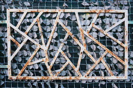 Wallpaper background of rusty white geometric structure on a green fabric wall.の写真素材