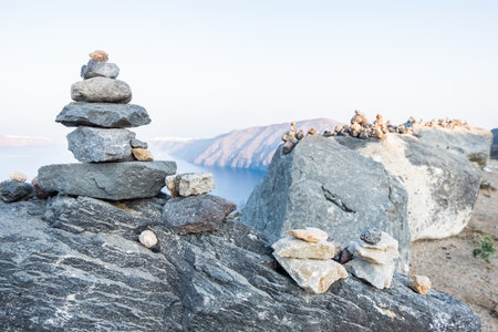 Stones tower with Oia and Santorini island on the background.の写真素材