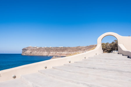 White stone staircase with blue beach and mountains of Santorini on the backgroundの写真素材