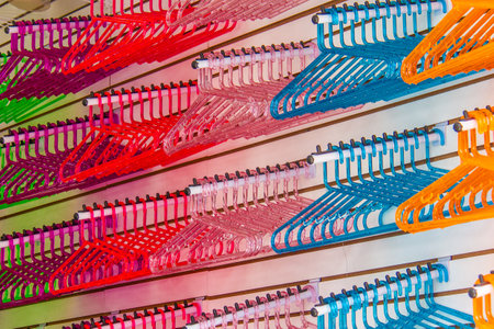 Green, blue, orange, pink, bordeaux and red colorful clothes hangersの写真素材