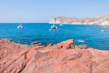Beautiful view Red beach with boats of Santorini Island in Greeceの写真素材