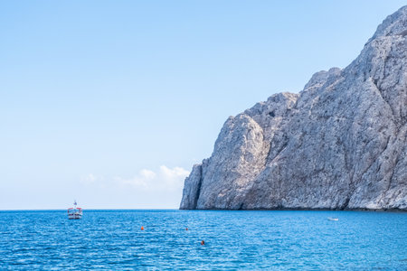 Peaceful sea water with boat near the coast of Santorini island, Greece.の写真素材