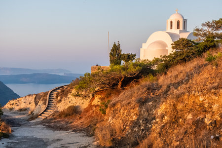 White church on a hill at sunrise at Santorini island, Greeceの写真素材