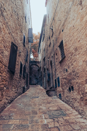 Ancient buildings in an alley of a village built in the mountains in Tuscanyの写真素材