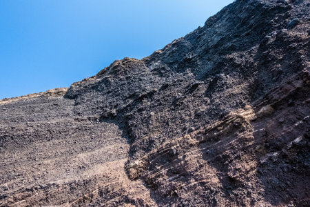 The red earth of the rocky coast of the red beach in santoriniの写真素材