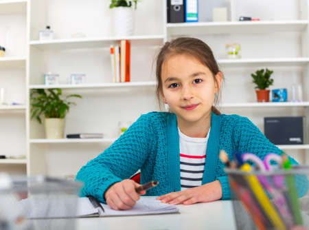 Beautiful girl working on her school project at home.