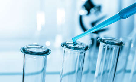 Pipette adding fluid to one of several test tubes .medical glassware.の写真素材