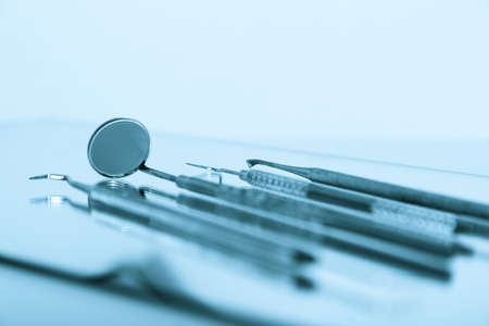 Dental tools and equipment over blue .Set of metal medical equipment tools for teeth dental careの写真素材