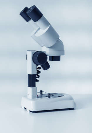 Scientific microscope lens on blue , A microscope is an instrument used to see too small objects