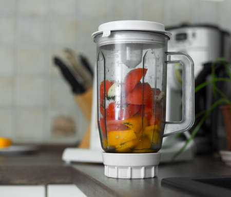 Blender with fresh vegetables on kitchen table.の写真素材