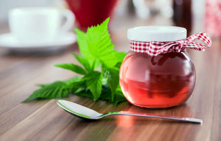 Glass can full of honey on old wooden tableの写真素材