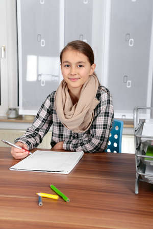 Beautiful  girl working on her school project at home.