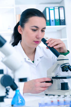 Woman working with a microscope in a lab.Toning image.