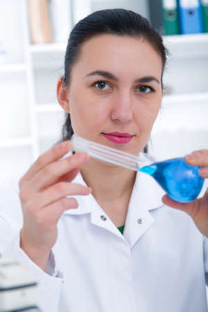 Young Female Scientist Analyzing Sample In Laboratory.laboratory assistant analyzing a sample.Toning...