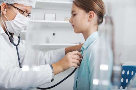 Doctor check throat of little girl..toned image