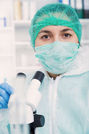 Woman working with a microscope in a lab.Toning image