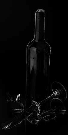 Red Wine bottle and broken glass on dark background?の写真素材