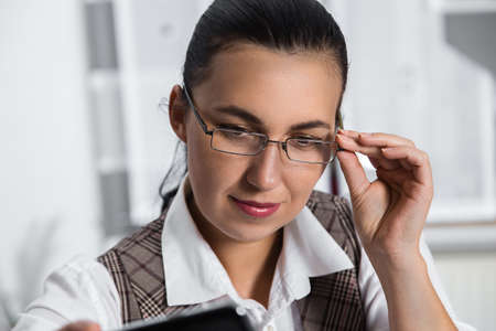 Young businesswoman sitting at workplace and working with papers in officeの写真素材