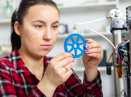 Female Designer Working With 3D Printer .