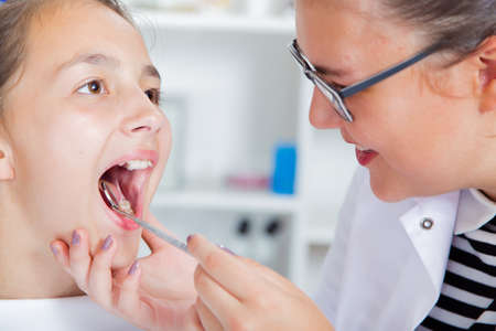 Close-up of little girl opening his mouth wide during treating hの写真素材