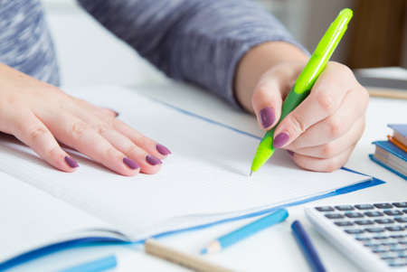 Handwriting, hand writes with a pen in a notebook.の写真素材