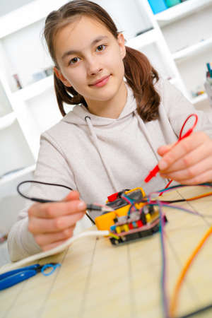 Teen girl working  on CNC  machinery.