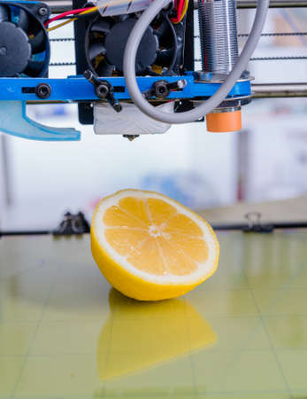 Ripe slice of yellow lemon citrus fruit . 3d printer of the device during the processe
