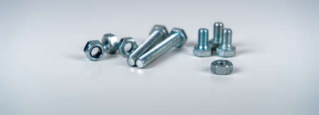 Metal screw, bolt and nuts on white background..