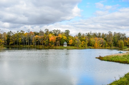 View of an autumn park with colorful leaves and a pond in the foregroundの写真素材