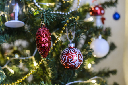 A Christmas toy hanging on a Christmas tree against the backdrop of a garlandの写真素材