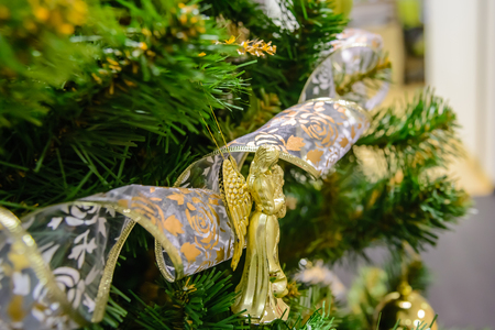A Christmas toy hanging on a Christmas tree against the backdrop of a garlandの写真素材