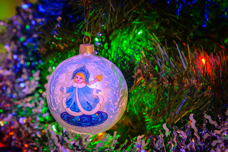 A Christmas toy hanging on a Christmas tree against the backdrop of a garlandの写真素材