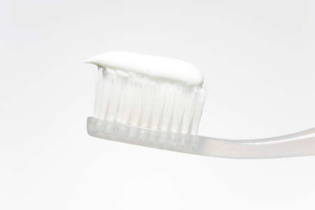 Hygiene products: toothpaste on the toothbrush in a light tone.の写真素材