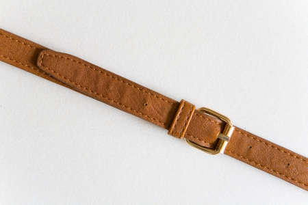 Brown leather belt with a golden buckle.の写真素材