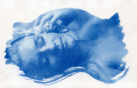A naked girl with her hair loose listens to the sound of the ocean emitted by the shell. Attention! This is a unique classic blue cyanotype. When enlarged, the texture of the watercolor paper on which it is printed is visible. Handmade.の写真素材