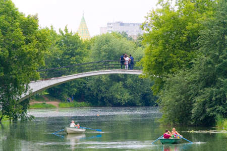 Moscow, Russia, June 16, 2013: The day off. People go boating. Poplar fluff lies on the surface of the water. Silver-grape pond.のeditorial素材