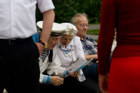 Moscow, Russia. July 28, 2013: Elderly people in the uniform of the Navy are reviewing the booklet. Izmailovsky Park.のeditorial素材