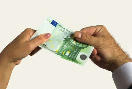 Finance. A man's hand and a woman's hand hold a one hundred euro bill.