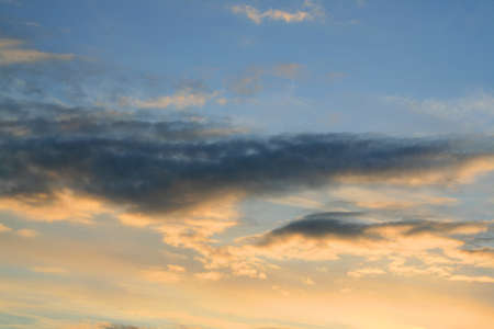 Golden clouds in the rays of the setting sun.