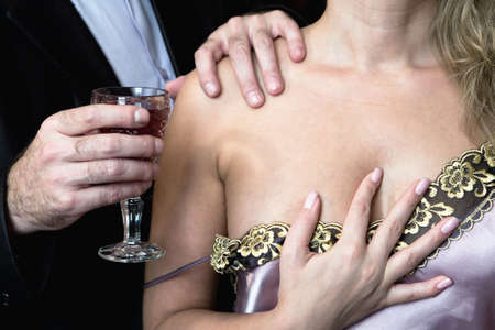 A man offers a woman to drink wine. Sexual harassment.の写真素材